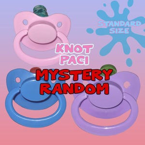 Op de afbeelding: Drie fopspenen in roze, blauw en paars worden getoond tegen een gradiënt achtergrond. De fopspenen hebben een ronde speen en een ringhandvat. Tekst op de afbeelding luidt "Knot Paci", "Mystery Random" en "Standard Size".