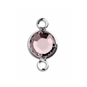 May include: A silver-toned connector with a round, clear, light pink crystal in the centre. The connector has two loops on either side.