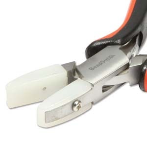 May include: Close-up of a pair of silver-toned jewelry pliers with black and orange handles. The pliers have white, ceramic jaw tips. The text "Beadsmith" is printed on the pliers.