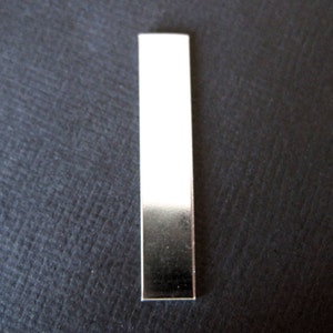 May include: A silver metal bar with a smooth, reflective surface.