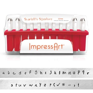 May include: A set of metal letter stamps in a red and white plastic case. The case has the text "Scarlett's Signature" and "ImpressArt". Below the case are stamped lowercase letters, numbers, and symbols. The stamp set is 2.5 mm.
