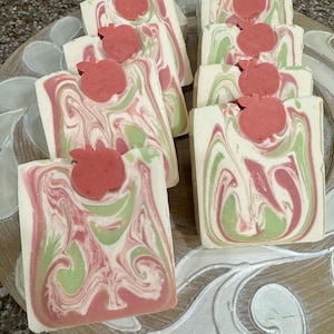 Red apple fragranced small batch, hand made soap bars, with a fun swirl design, topped with a red apple soap embed.