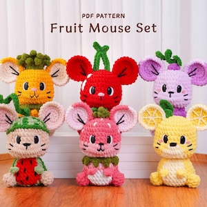 May include: A collection of crocheted fruit-themed mice. The mice are in various colors, including yellow, red, pink, and purple, with fruit-inspired details like watermelon, lemon, and strawberry. The text "PDF PATTERN Fruit Mouse Set" is at the top.