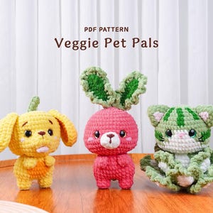 May include: Three handmade crochet veggie pet pals: a yellow dog, a pink radish bunny, and a green watermelon cat. The text "PDF PATTERN Veggie Pet Pals" is at the top. The toys are on a wooden surface.
