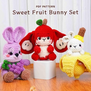 Op de afbeelding: Drie gehaakte konijnen, elk ontworpen als een ander fruit. De konijnen zijn in paars, rood en geel. De tekst "Sweet Fruit Bunny Set" staat bovenaan de afbeelding, wat duidt op een patroon.