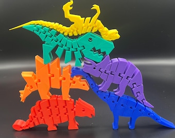 May include: A stack of five colorful articulated dinosaur toys. The dinosaurs are made of plastic and are in the colors yellow, green, orange, purple, and blue.