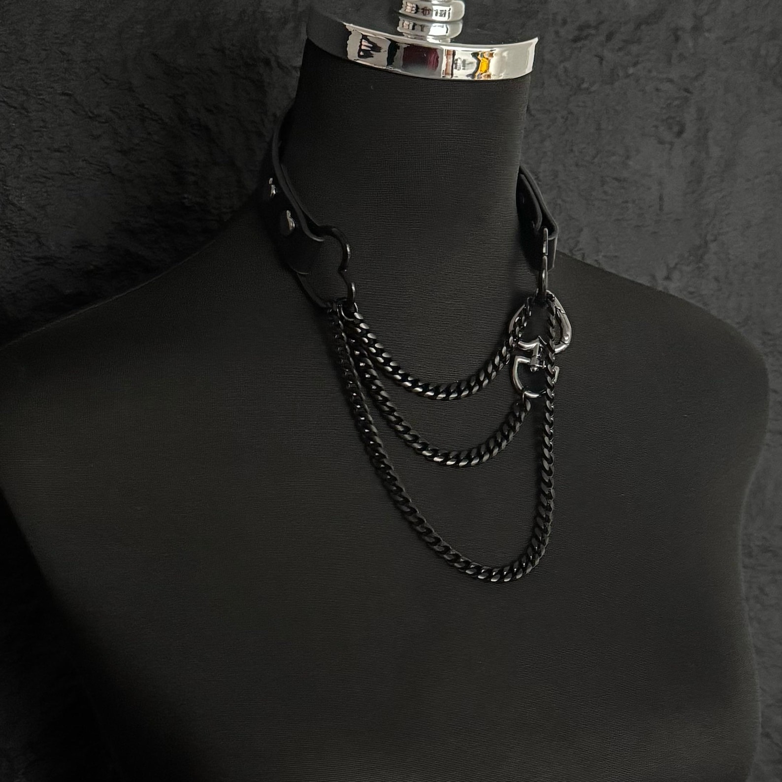 Black gothic collar with layered black metal chains draped elegantly on mannequin, handmade statement choker.