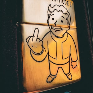 Fallout Vault Boy Middle Finger Zippo Lighter with Nuka-Cola Logo & “Taste the Apocalypse” Quote