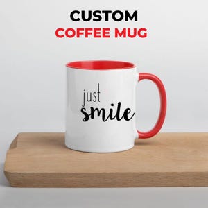 May include: White coffee mug with a red interior and handle. The mug features the words "just smile" in black script. The text "CUSTOM COFFEE MUG" is above the mug.