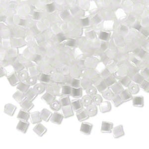 May include: A pile of small, clear, square-shaped glass beads. The beads are translucent and have a slightly iridescent finish.