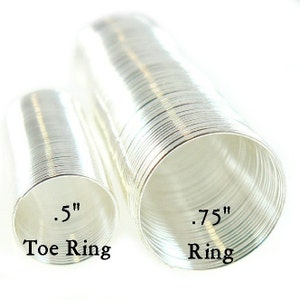 May include: Two silver rings, one is a toe ring measuring 0.5 inches in diameter and the other is a ring measuring 0.75 inches in diameter.  The rings are made of thin, coiled wire.