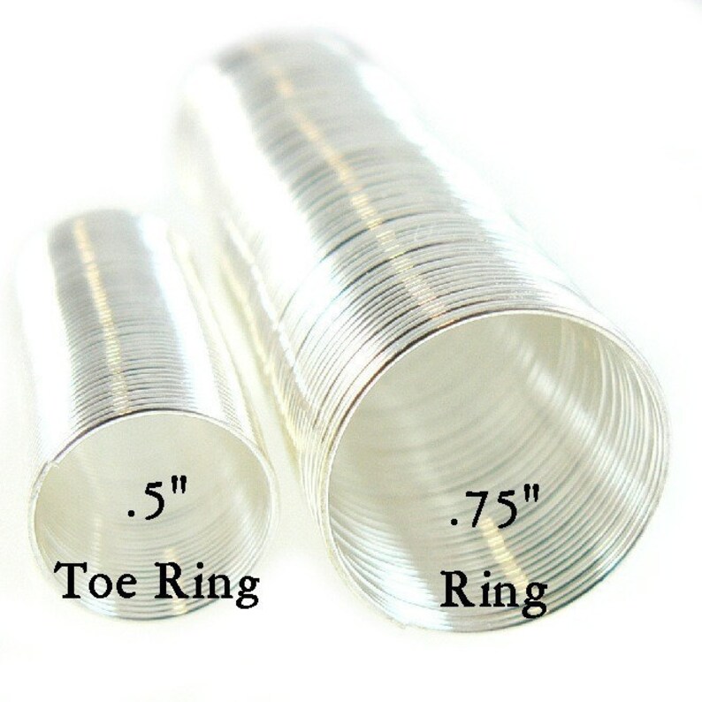 May include: Two silver rings, one is a toe ring measuring 0.5 inches in diameter and the other is a ring measuring 0.75 inches in diameter.  The rings are made of thin, coiled wire.