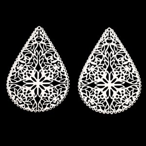 May include: A pair of white metal earrings with a delicate, intricate floral design. The earrings are shaped like teardrops and have a cutout pattern.