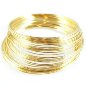 May include: A stack of gold-colored wire rings, each ring is slightly smaller than the one below it.