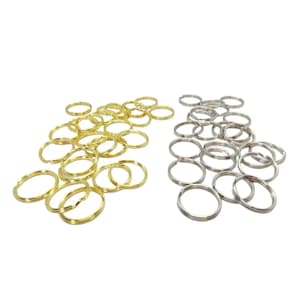 May include: A collection of gold and silver-colored split key rings. The key rings are round and made of metal. The gold key rings are on the left, and the silver key rings are on the right, against a white background.