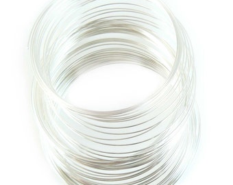 May include: A coil of silver wire, tightly wound into a circular shape. The wire is shiny and reflective, and the coils are neatly stacked on top of each other.