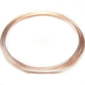 May include: A coil of rose gold colored wire. The wire is thin and shiny.