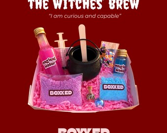 Könnte beinhalten: Ein Set mit der Aufschrift THE WITCHES' BREW und I am curious and capable, bestehend aus einem schwarzen Kessel, einem Holzrührer, einer Spritze, zwei Flaschen magical water, zwei Beuteln BOXXED-Pulver, einer kleinen Glitzerflasche und Pailletten.