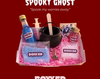 Könnte beinhalten: Ein Set bestehend aus einem schwarzen Kessel mit Holzrührer, einer Spritze, zwei Glasflaschen mit der Aufschrift Magical Water, zwei Beuteln mit Pulver der Marke BOXXED, einem kleinen Glitzerfläschchen und einer Tüte mit Anhängern auf rosa Papier.