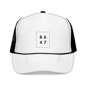 Pode incluir: Boné de caminhoneiro branco com uma malha preta na parte de trás. A parte frontal do boné tem um quadrado preto com os números 86 e 47 dentro.