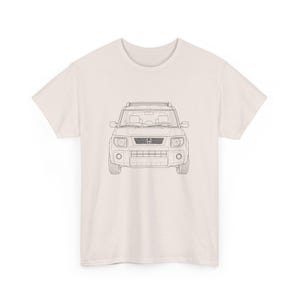May include: Cream-colored t-shirt featuring a black line drawing of a Honda Element SUV. The graphic shows the front view of the vehicle, including headlights, grille, and roof rack. The shirt is made of a soft material and has a classic crew neck.
