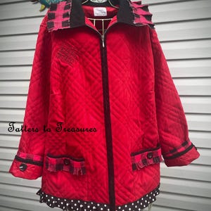 May include: A quilted red jacket with a black zipper, collar, and trim. The jacket features a black and red plaid pattern on the collar and cuffs, with black polka dot trim at the hem. The text "Tatters to Treasures" is visible.