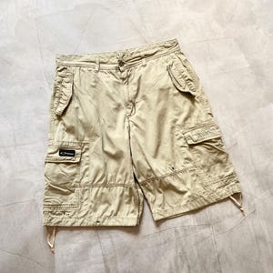 Puede incluir: Pantalones cortos cargo de color caqui con múltiples bolsillos y cierre de botón. Los pantalones cortos tienen el logotipo de Oakley en un bolsillo. Los pantalones cortos tienen un ajuste relajado y detalles de cordón en el dobladillo.