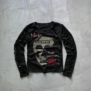 May include: Black long-sleeve shirt with a skull graphic and the text "SENPOT" and "PUNK BONDAGE" on the front. The sleeves have black leather straps with silver studs.