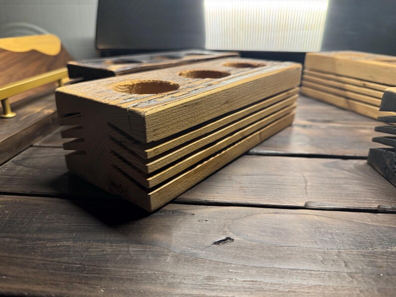 May include: A wooden organizer with three round holes, perfect for storing small items like pens, pencils, or brushes. The organizer has a rustic, reclaimed wood look and is made of natural wood.