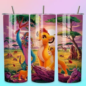 May include: A set of three stainless steel tumblers with a colorful illustration of characters from The Lion King. The design features Simba, Nala, and Rafiki in a vibrant savanna landscape with a sunset backdrop. Each tumbler has a silver lid and straw.