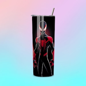 Puede incluir: Un vaso negro y rojo con un gr&aacute;fico de superh&eacute;roe. El dise&ntilde;o incluye un emblema de ara&ntilde;a en el pecho. El vaso tiene una tapa plateada y una pajita plateada. Altura: aproximadamente 20 cm.
