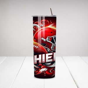 Op de afbeelding: Een rode en zwarte roestvrijstalen tumbler met een voetbalhelm en een voetbalafbeelding. De tumbler heeft een wit ontwerp met de tekst "CHIEF" erop.
