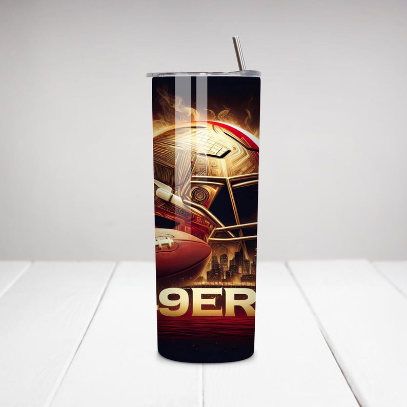 May include: A stainless steel tumbler with a gold football helmet and a football on a black background. The text "9ER" is visible on the tumbler.