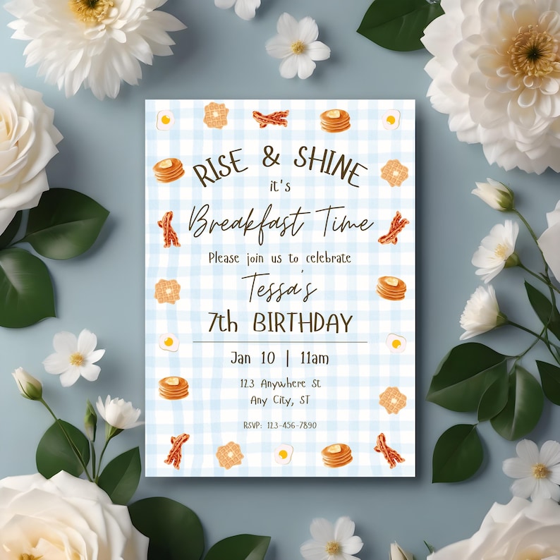 May include: A breakfast-themed birthday invitation with a blue gingham background. The text reads "Rise & Shine, it's Breakfast Time" and includes details for Tessa's 7th birthday. Decorative elements include illustrations of pancakes, bacon, waffles, and eggs.