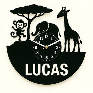 May include: Black wall clock featuring a jungle scene with a monkey, elephant, giraffe, and tree silhouettes. The clock face is black with white numbers and hands. The name "LUCAS" is displayed in white.