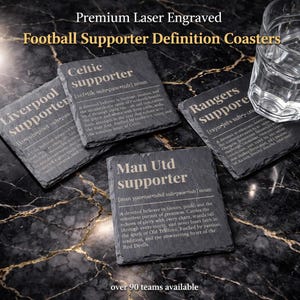 May include: Four slate coasters with engraved text, including "Celtic supporter," "Liverpool supporter," "Rangers supporter," and "Man Utd supporter." The coasters are black and sit on a dark, patterned surface. The text includes definitions.