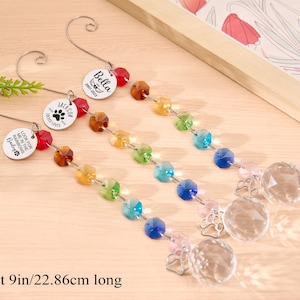 May include: Three decorative pet memorial suncatchers, each about 9 inches long, with a rainbow of faceted beads and a clear crystal ball. Each has a metal charm with a pet's name and paw print.