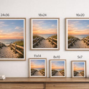 May include: Framed beach landscape art prints in various sizes, including 24x36 inches, 18x24 inches, 16x20 inches, 11x14 inches, 8x10 inches, and 5x7 inches. The prints depict a sandy path leading to the ocean at sunset, framed in light wood.