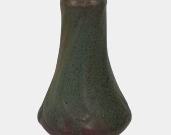 May include: A small, handcrafted ceramic vase with a textured surface. The vase has a dark green and brown color scheme, with a flared base and a narrow neck. The vase is approximately 6 inches tall.