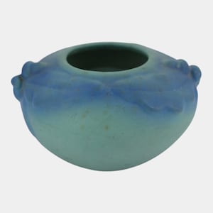 May include: A small, round ceramic bowl featuring a matte finish with a gradient color transition from a deep blue at the top rim to a lighter, muted teal green at the base. The exterior is decorated with a raised, molded leaf pattern.