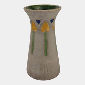 May include: A gray ceramic vase with a flared top and a textured surface. The vase features yellow and green floral designs with blue accents. The interior rim is green.