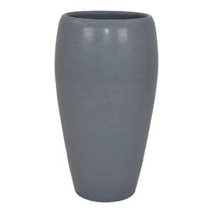 May include: A tall, gray ceramic vase with a smooth, slightly textured surface. The vase has a rounded, cylindrical shape.