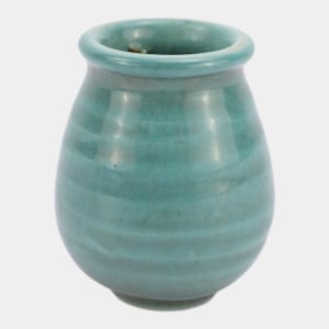 May include: A small, bulbous ceramic vase with a smooth, glossy teal glaze. The vessel features a rounded body with subtle, horizontal ridged textures encircling the exterior and a wide, circular opening at the top with a thick, rolled rim.