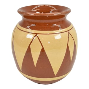 May include: A brown ceramic vase with a yellow and brown geometric pattern. The vase has a rounded body and a wide mouth.