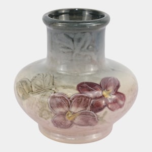 May include: A ceramic vase with a bulbous body and a short neck, featuring a gradient finish transitioning from dark gray at the top to a pale pink base. The surface is decorated with embossed purple flowers with yellow centers and green leaves.