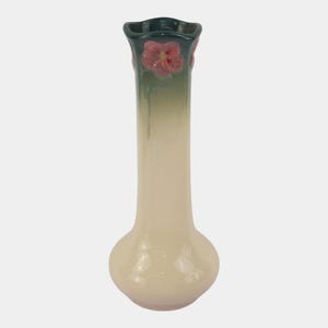 May include: A tall, slender ceramic vase with a bulbous base and a flared, wavy rim. The vase features a gradient color scheme, transitioning from a creamy off-white at the bottom to a deep forest green at the top, accented by a pink flower.
