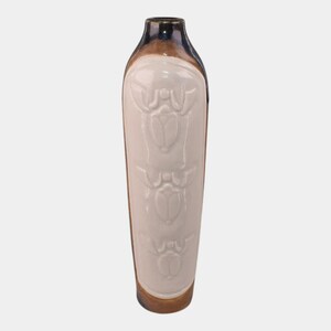 May include: Tall ceramic vase with a cream-colored central panel featuring a repeating embossed design. The top rim is dark blue, transitioning to a brown band, and the base is also brown. The vase has a rectangular shape.