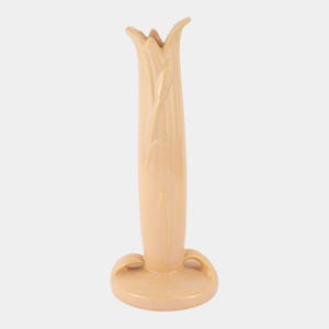 May include: A tall, peach-colored ceramic vase with a tulip-like design. The vase has a flared top with multiple points, a long, slender body, and a rounded base with two curved handles. The vase is approximately 10 inches tall.