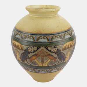 May include: A round, yellow ceramic vase with a wide body and a narrow neck. The vase features a decorative band with green, blue, and brown patterns, and a central design of stylized mushrooms and insects.