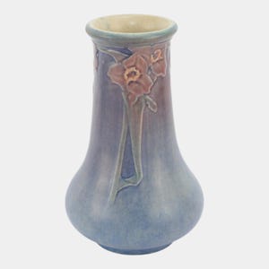 May include: A blue ceramic vase with a bulbous base and a flared rim. The vase features a floral design in shades of brown and green. The vase is approximately 8 inches tall.